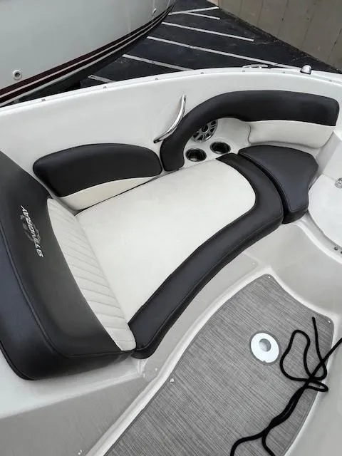 Slide: The Image of 2018 Stingray 235 LR boat interior with cushioned seating and cup holders. - 13