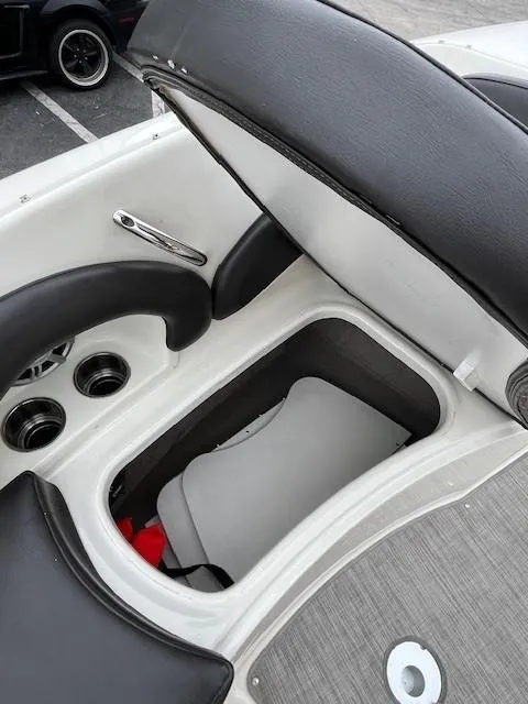 Slide: The Image of 2018 Stingray 235 LR boat interior storage compartment with black and white seating. - 14