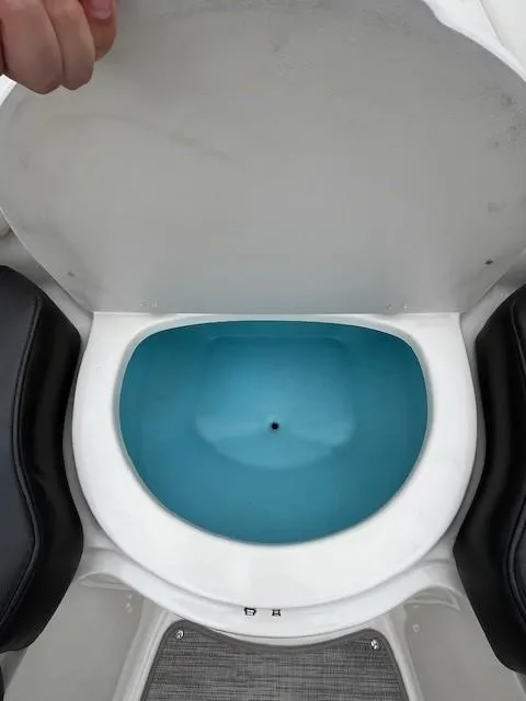 Slide: The Image of Livewell compartment in a 2018 Stingray 235 LR boat, featuring a blue interior. - 16