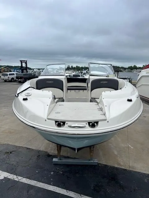 Slide: The Image of 2018 Stingray 235 LR boat on display at a marina under cloudy skies. - 2