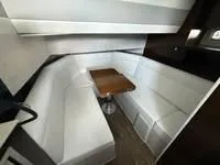 Slide: The Image of 2022 Cruisers 42 GLS yacht interior with white seating and wooden table. - 28