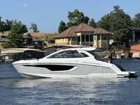 Slide: The Image of 2022 Cruisers 42 GLS yacht cruising on a lake near waterfront homes. - 4