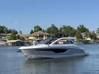 Slide: The Image of 2022 Cruisers 42 GLS yacht on a serene lake with houses in the background. - 5