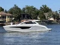 Slide: The Image of 2022 Cruisers 42 GLS yacht cruising on a serene lake with waterfront homes in the background. - 8