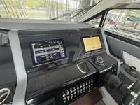 Slide: The Image of 2022 Cruisers 42 GLS yacht interior with seating and bar area, docked by the water. - 20