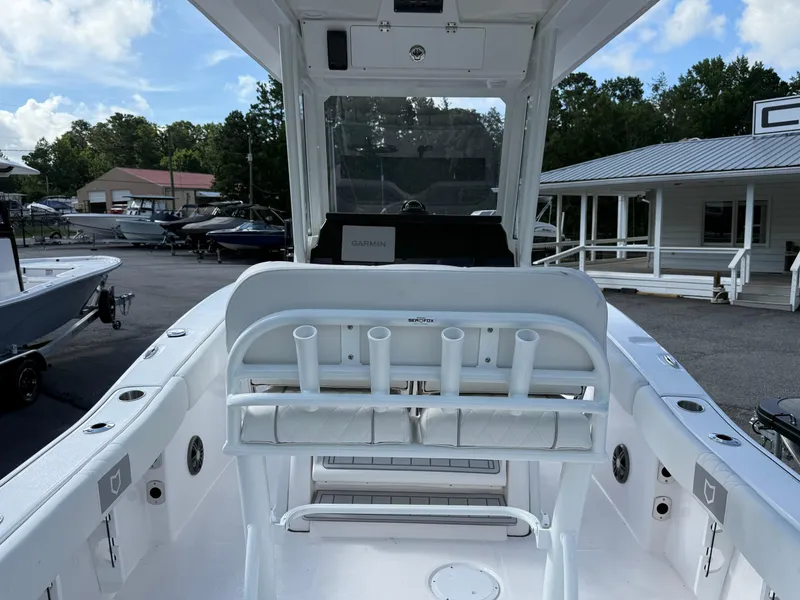 Slide: The Image of 2026 Sea Fox 228 Commander boat interior with rod holders and Garmin equipment, docked outdoors. - 3