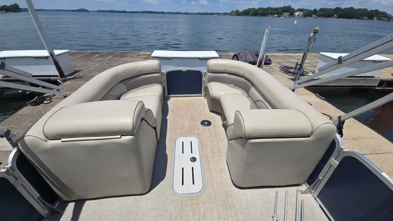 Slide: The Image of 2017 Premier 240 SunSation pontoon boat with beige seating, docked by a scenic lake. - 11