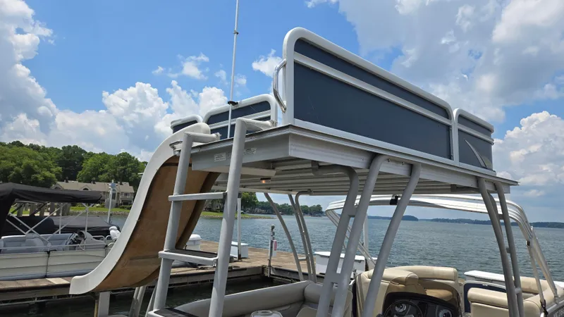Slide: The Image of 2017 Premier 240 SunSation pontoon boat with upper deck and slide on a sunny lake. - 14