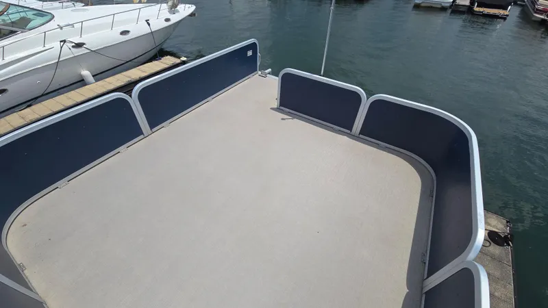 Slide: The Image of 2017 Premier 240 SunSation pontoon boat deck at marina, with surrounding water and docked boats. - 16