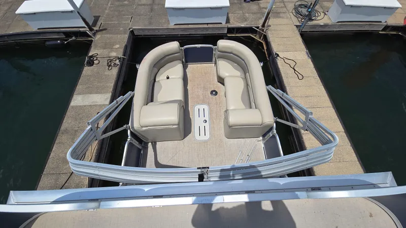 Slide: The Image of 2017 Premier 240 SunSation pontoon boat with beige seating, docked at a marina. - 17