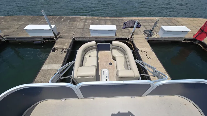 Slide: The Image of 2017 Premier 240 SunSation pontoon boat docked, featuring spacious seating and water view. - 18