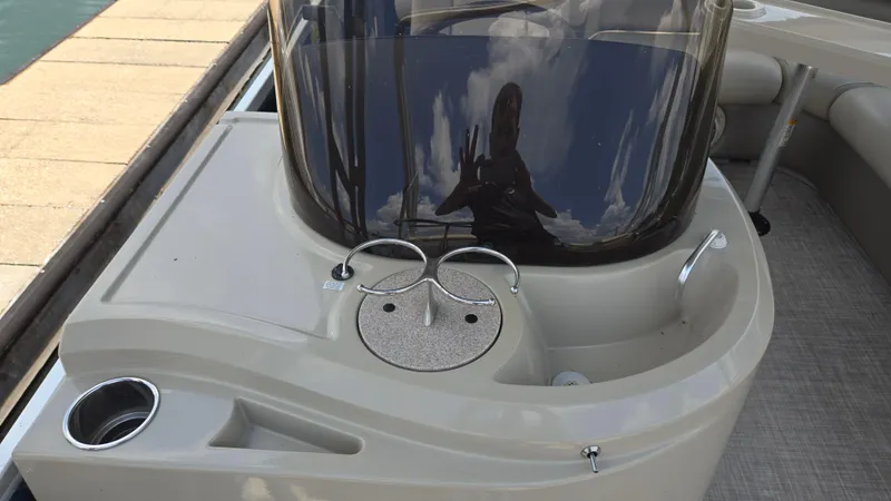 Slide: The Image of 2017 Premier 240 SunSation boat console with cup holders and windshield, docked by the water. - 32