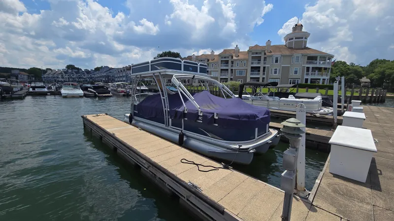 Slide: The Image of 2017 Premier 240 SunSation pontoon boat docked at marina with residential buildings in background. - 4