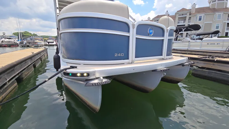 Slide: The Image of 2017 Premier 240 SunSation pontoon boat docked at marina, blue and white exterior. - 6