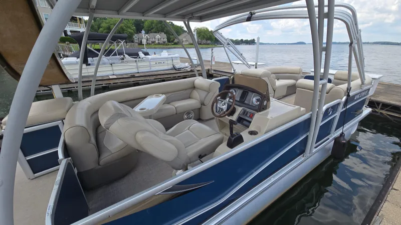 Slide: The Image of 2017 Premier 240 SunSation pontoon boat docked, featuring spacious seating and modern controls. - 9