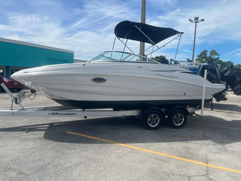 The Image of 2022 Crownline Eclipse E235 XS boat on trailer, parked outdoors under blue sky. - 0