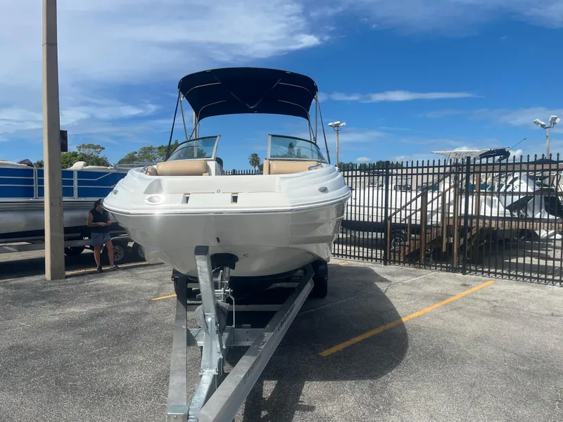 Slide: The Image of 2022 Crownline Eclipse E235 XS boat on trailer in parking lot. - 2