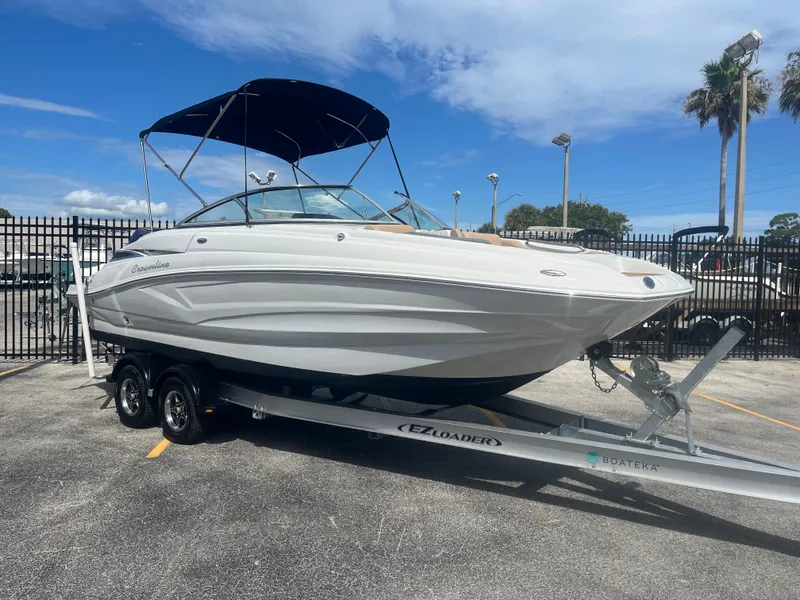 Slide: The Image of 2022 Crownline Eclipse E235 XS boat on trailer, parked outdoors under blue sky. - 3
