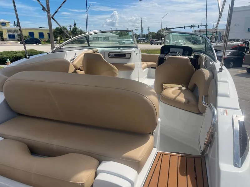 Slide: The Image of 2022 Crownline Eclipse E235 XS boat interior with beige seating and modern dashboard. - 7