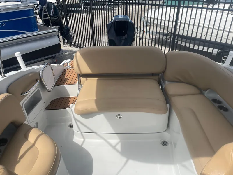 Slide: The Image of 2022 Crownline Eclipse E235 XS boat interior with tan seating and white deck. - 9