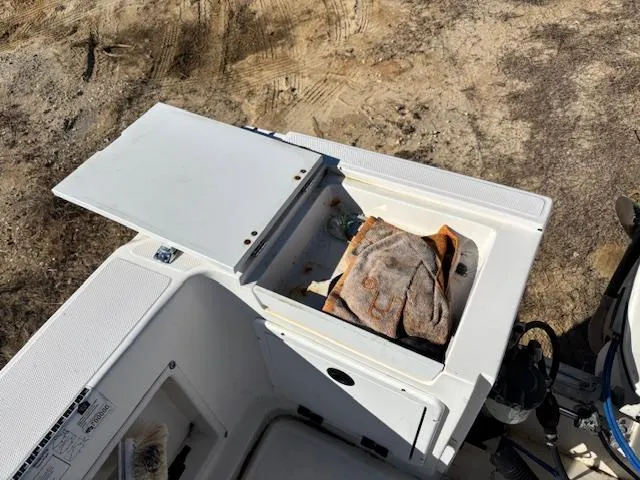 Slide: The Image of 1997 Wellcraft 210 Coastal boat storage compartment with open lid and towel inside. - 11