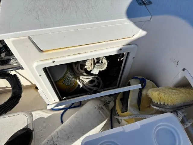 Slide: The Image of Storage compartment on a 1997 Wellcraft 210 Coastal boat with ropes and cleaning supplies. - 13