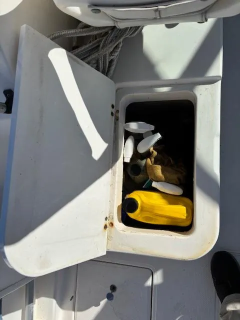 Slide: The Image of Open storage compartment on a 1997 Wellcraft 210 Coastal boat with various items inside. - 21
