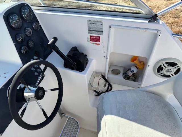 Slide: The Image of 1997 Wellcraft 210 Coastal boat cockpit with steering wheel and control panel. - 22