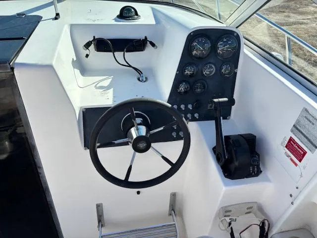 Slide: The Image of 1997 Wellcraft 210 Coastal boat dashboard with steering wheel and instrument panel. - 23