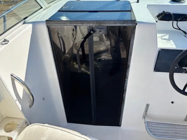 Slide: The Image of 1997 Wellcraft 210 Coastal boat interior with black cabin door and steering wheel. - 26