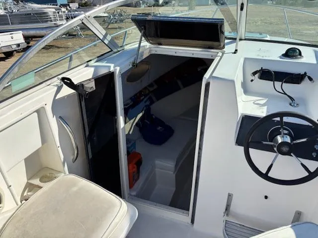 Slide: The Image of 1997 Wellcraft 210 Coastal boat interior with steering wheel and cabin entrance. - 29