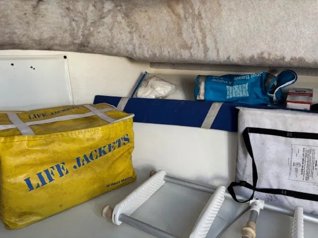 Slide: The Image of Storage area in a 1997 Wellcraft 210 Coastal boat with life jackets and safety equipment. - 34