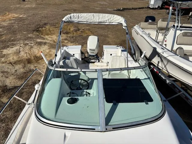 Slide: The Image of 1997 Wellcraft 210 Coastal boat with canopy and outboard motor, parked on dry land. - 43