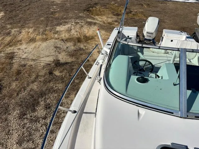 Slide: The Image of 1997 Wellcraft 210 Coastal boat on dry land, showing cockpit and steering wheel. - 44