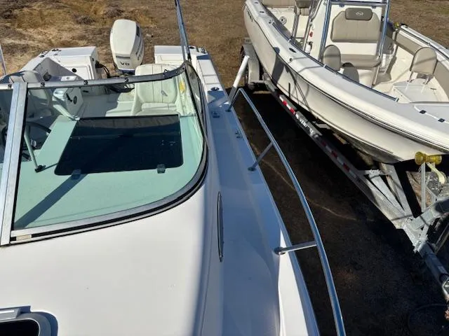 Slide: The Image of 1997 Wellcraft 210 Coastal boat on trailer, featuring open deck and windshield. - 45