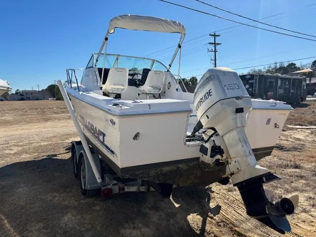 Slide: The Image of 1997 Wellcraft 210 Coastal boat on trailer with Evinrude outboard motor, parked outdoors. - 5