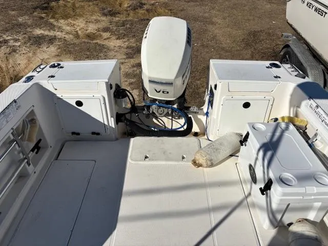 Slide: The Image of 1997 Wellcraft 210 Coastal boat interior with V6 engine, storage compartments, and cooler on deck. - 8