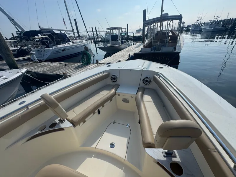 Slide: The Image of 2023 Scout 255 LXF boat docked at marina, featuring spacious seating and modern design. - 15