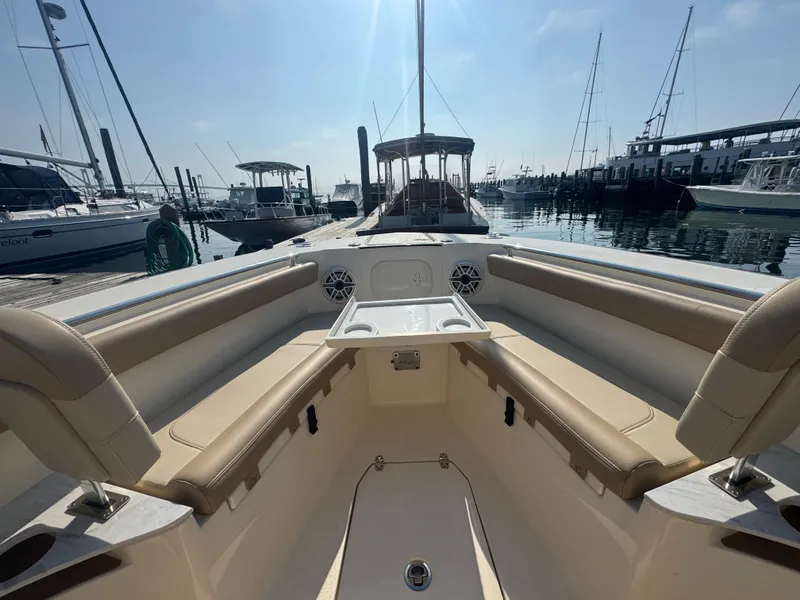 Slide: The Image of 2023 Scout 255 LXF boat interior at marina, featuring tan seating and sleek design. - 17