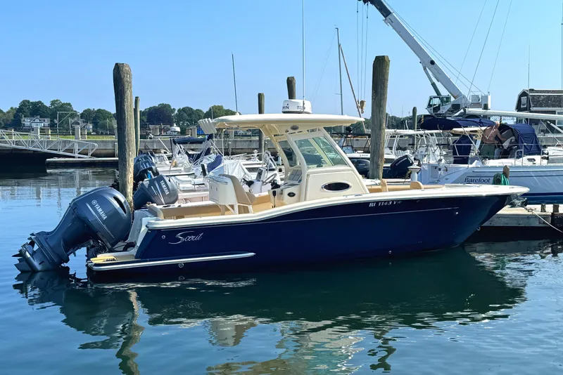 Slide: The Image of 2023 Scout 255 LXF boat docked with Yamaha engines in a marina. - 2