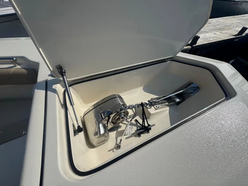 Slide: The Image of 2023 Scout 255 LXF boat anchor compartment with open lid and chain. - 20