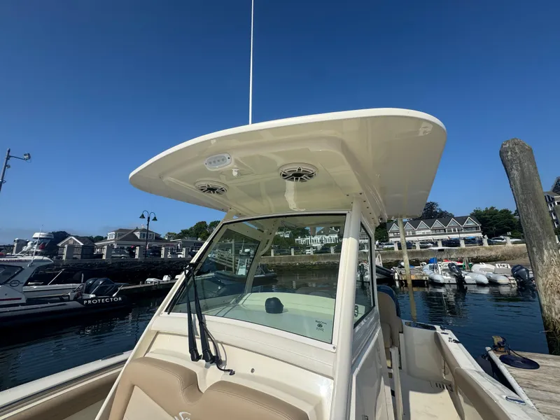 Slide: The Image of 2023 Scout 255 LXF boat docked at marina under clear blue sky. - 25