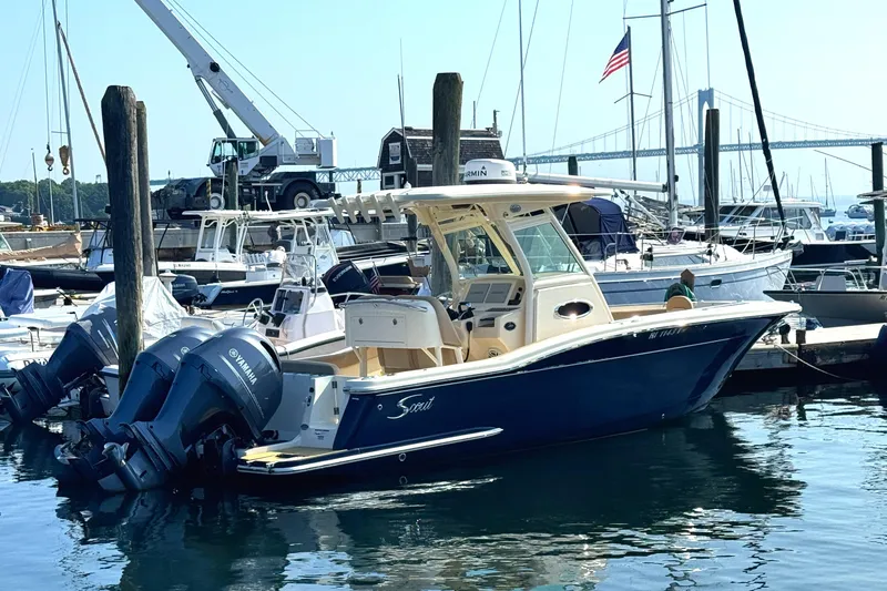 Slide: The Image of 2023 Scout 255 LXF boat docked in marina with Yamaha engines. - 3