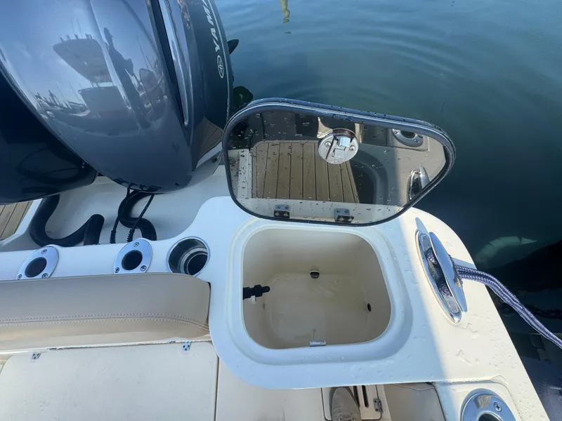 Slide: The Image of 2023 Scout 255 LXF boat with open storage compartment and Yamaha engine. - 34
