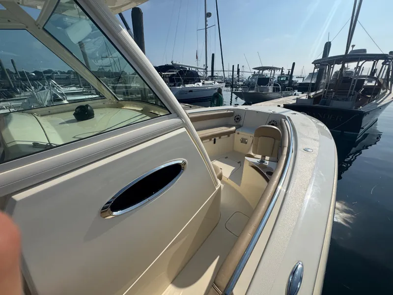 Slide: The Image of 2023 Scout 255 LXF boat docked at marina, showcasing sleek interior and seating. - 36