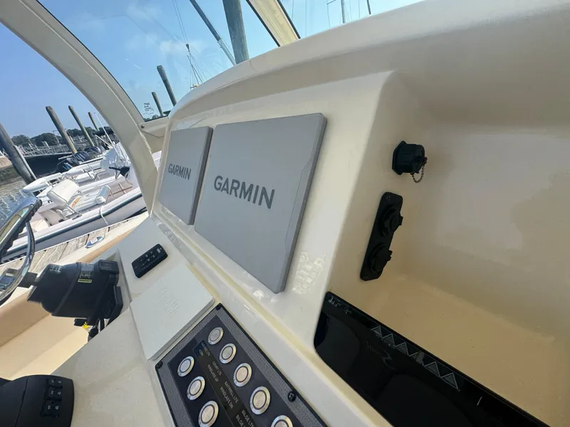 Slide: The Image of 2023 Scout 255 LXF boat dashboard with Garmin displays and control panel. - 41
