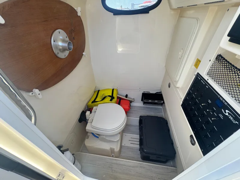 Slide: The Image of 2023 Scout 255 LXF boat interior with toilet, control panel, and storage compartments. - 42