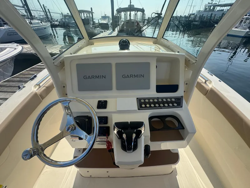 Slide: The Image of 2023 Scout 255 LXF boat dashboard with Garmin displays at marina. - 6