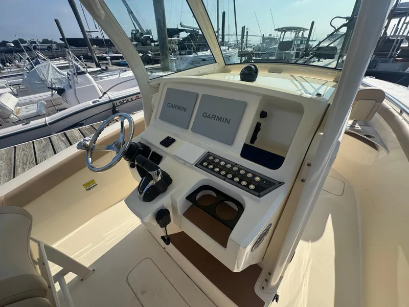 Slide: The Image of 2023 Scout 255 LXF boat dashboard with Garmin navigation, docked at marina. - 8