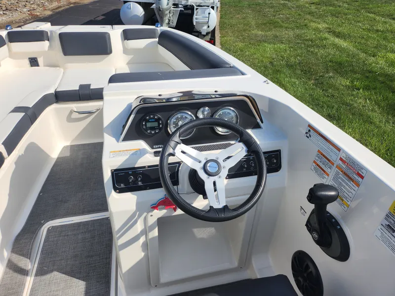 Slide: The Image of 2021 Bayliner DX 2000 boat cockpit with steering wheel and dashboard controls. - 14